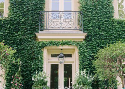 A table set up in front of a house with ivy growing on it.