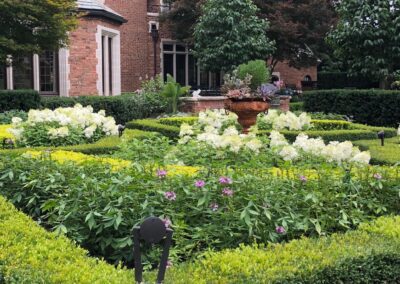 A garden in front of a brick house.