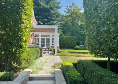 A garden with bushes and steps leading to a house.