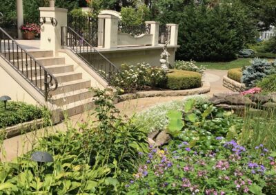 A garden with a fountain and steps leading to a garden.