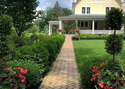 A brick walkway leading to a house.