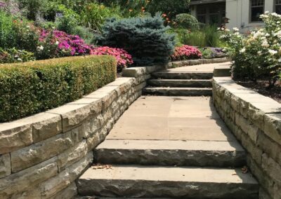 A stone stairway leading to a flower garden.