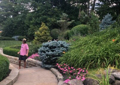 A man walking down a path in a garden.