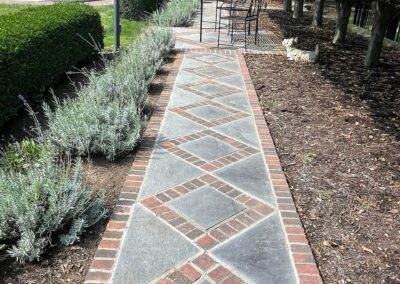 A walkway with a brick pattern in a garden.